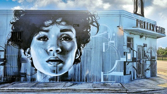 Ein kunstvolles großes Bild einer jungen Frau auf einem Gebäude © Christina Angelina/Ease One Foto: Christina Angelina/Ease One