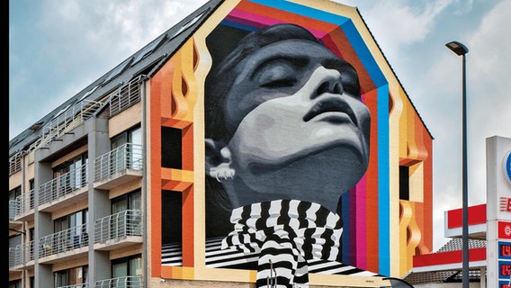 Ein Gesicht einer Frau als Wandbild in schwarz-weiß auf einem Wohngebäude © Medianeras Foto: Medianeras