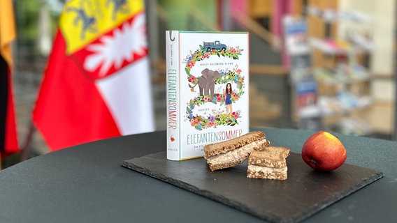 Zwei Schwarzbrothälften mit Thunfischaufstrich, ein Apfel und ein Roman auf einem Tisch - Folge 90 des Literaturpodcasts eat.READ.sleep © NDR Foto: Torsten Heitmann