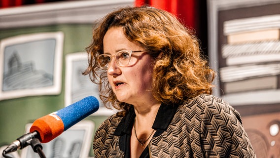 Julia Schoch vor einem Mikrofon. © Heinekomm Foto: Manfred Scharnberg
