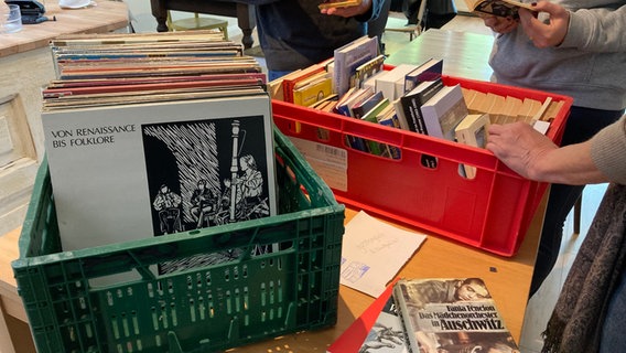 Zwei volle Kisten mit Büchern und Platten stehen auf einem Tisch. Zwei volle Kisten mit Büchern und Platten stehen auf einem Tisch. © Antonia Reiff / NDR Foto: Antonia Reiff