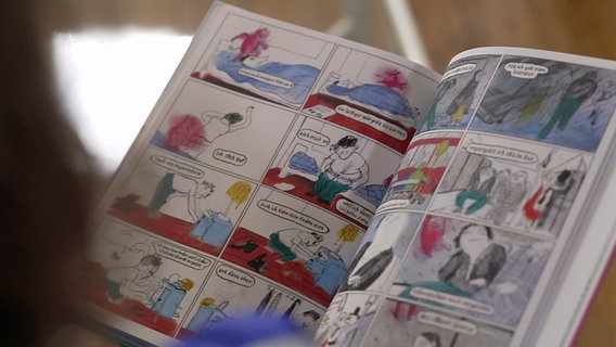 Eine aufgeschlagene Seite des Comicbands "Schwule Mädchen" zeigt eine Doppelseite des Comics zu dem Song "Silberfische". Eine aufgeschlagene Seite des Comicbands "Schwule Mädchen" zeigt eine Doppelseite des Comics zu dem Song "Silberfische". © NDR