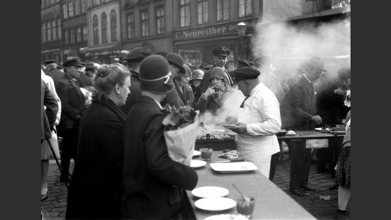Foto aus dem Bildband "Max Halberstadt. Der Fotograf": Viele Menschen an einem Wurststand auf dem Altonaer Fischmarkt © Hirmer Verlag 