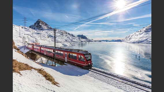 Ein Zug im Schnee vor einem vereisten Gewässer © Axel Bozier, Monisha Rajesh, Zugvögel, Gestalten, 2021 Foto: Axel Bozier