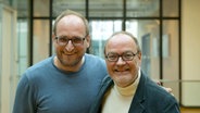 Schauspieler, Autor und Hörspielsprecher Jens Wawrczeck (rechts) steht lächelnd neben NDR Redakteur Daniel Kaiser im Landesfunkhaus des Norddeutschen Rundfunks Hamburg © NDR Foto: Fabian Möller