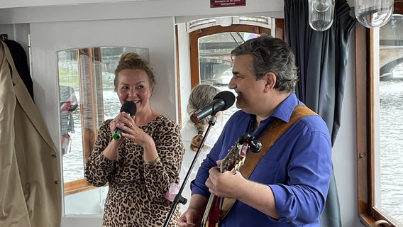 Simone Buchholz und Bernd Begemann lesen und singen auf einem Ausflugschiff vor Publikum © NDR Foto: Danny Marques Marcalo