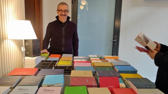 Der Gründer vom Verlag "Edition Korrespondenzen", Franz Hammerbacher, hinter seinem Büchertisch. Der Gründer vom Verlag "Edition Korrespondenzen", Franz Hammerbacher, hinter seinem Büchertisch. © NDR Foto: Svenja Estner