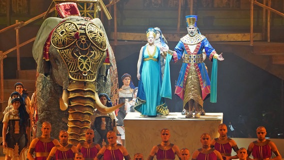 Szene aus dem Opern-Spektakel "Aida" in der Hamburger Barclays Arena: Zwei Sänger stehen neben einer lebensgroßen Elefantenpuppe. © picture alliance/dpa Foto: Marcus Brandt