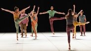 Männer und Frauen und bunter Alltagskleidung tanzen Ballett. © Christophe Bernard 