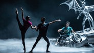 Eine Frau und ein Mann tanzen Ballett, im Hintergrund sitzt ein Tänzer auf einer Skulptur. © Birmingham Royal Ballet/ Johan Persson Foto: Johan Persson