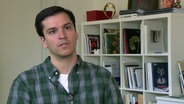 Hamburgs Ballett-Intendant Demis Volpi sitzt an einem Schreibtisch © NDR 