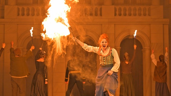 Maike Jacobs mit einer brennenden Fackel in "Der Diamantenherzog und das brennende Schloss" am Staatstheater Braunschweig © Marc Stantiem Foto: Marc Stantiem