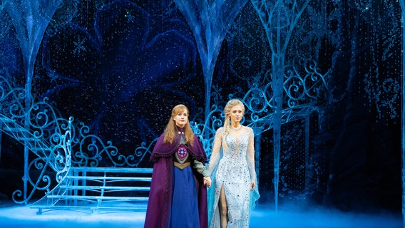Die Darstellerinnen Sabrina Weckerlin (Eiskönigin Elsa, r.) und Celena Pieper (ihre Schwester Anna) stehen nach einer Probe für das Musical "Die Eiskönigin" auf der Bühne im Stage Theater an der Elbe. © NDR.de Foto: Mathias Heller