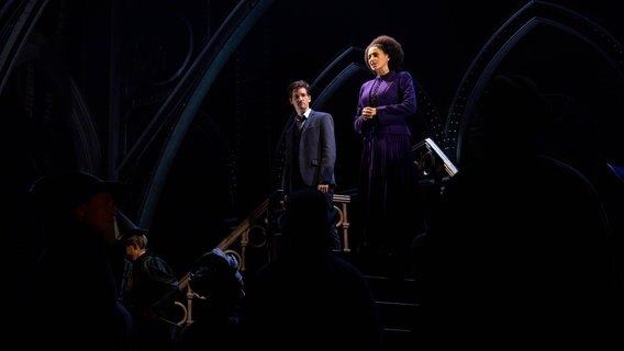 Schauspieler Markus Schöttl (hinten oben r) als Harry Potter und Schauspielerin Jillian Anthony (hinten oben l) als Hermine Granger stehen auf Treppen in einer Szene aus "Harry Potter und das verwunschene Kind" © NDR.de Foto: Mathias Heller
