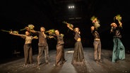 Sechs Personen auf einer Bühne halten Blumen in den Händen © Joachim Dette / Theaterhaus Jena Foto: Joachim Dette