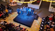 Sechs Personen stehen auf einer kleinen viereckigen schwarzen Bühne. Der Blick ist von oben nach unten. © Agnes Bührig / NDR Foto: Agnes Bührig / NDR