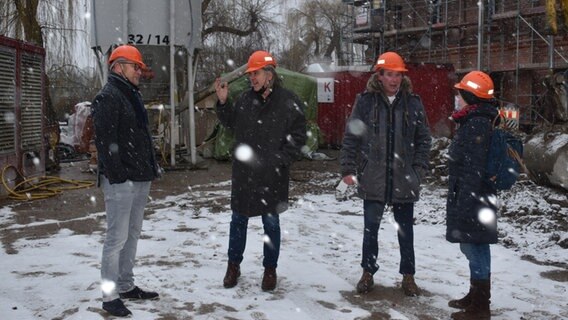 Parchims Bürgermeister Dirk Flörke mit den Intendanten des Mecklenburgischen Staatstheaters Schwerin, Hans-Georg Wegner, und dem Jungen Staatstheater Parchim, Thomas Ott-Albrecht sowie NDR Reporterin Karin Erichsen (v.l.n.r.) auf der Baustelle der Kulturmühle © NDR.de Foto: Karin Erichsen
