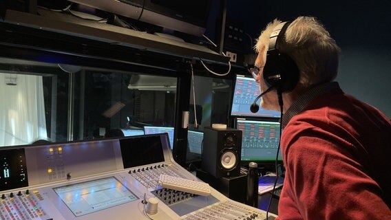Manfred Wildhage sitzt in einer Sprecherkabine mit Headset Manfred Wildhage sitzt in einer Sprecherkabine mit Headset © NDR Foto: Michael Brandt