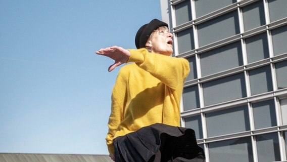 Eine Frau im gelben Pullover tanzt auf einem Dach © Thalia Theater/ Armin Smailovic Foto: Armin Smailovic