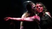 Eine Darstellerin in "Die Räuber" leckt eine andere Darstellerin, die mit Blut überströmt ist, das Gesicht ab. © Armin Smailovic Foto: Armin Smailovic