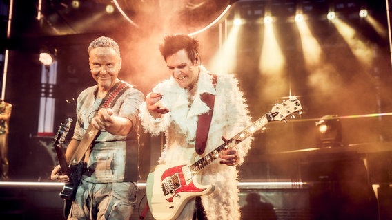 Zwei Männer stehen mit Gitarren in den Händen auf einer Bühne. Der mann links im Bild ist blond und der Mann rechts dunkelhaarig. © picture alliance/dpa/Rammstein | Jens Koch Foto: Jens Koch