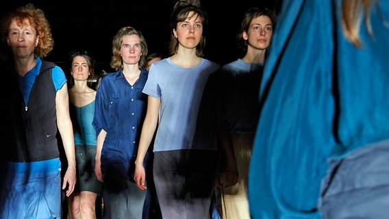 Frauen in blauer Kleidung stehen versetzt in einer Reihe und blicken nach vorn. © Öncü Gültekin Foto: Öncü Gültekin