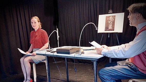 Zwei Personen (Inga Bruderek und Harald Polzin) sitzen auf einer Bühne an einem Tisch. © Inga Bruderek 