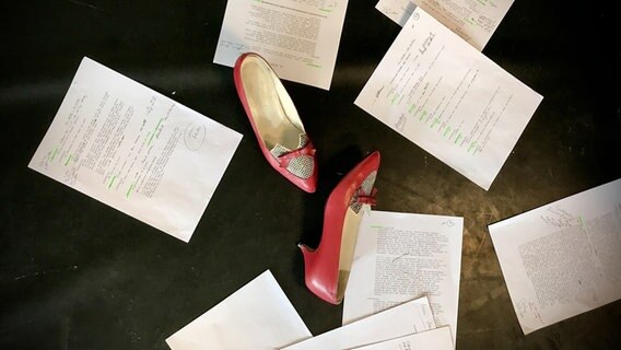 Zwei rote Schuhe liegen zwischen beschriebenen Zetteln © Inga Bruderek 
