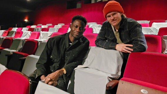 Die Schauspieler Yann Hendrik Mbiene und Lennart Lemster sitzen im Oberrang des Ernst Deutsch Theaters. © NDR Foto: Peter Helling
