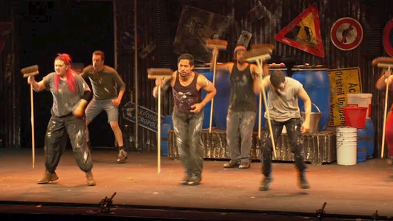 Acht Menschen mit Besen tanzen und spielen auf der Bühne in Hamburg bei "Stomp!" der Show © NDR Screenshot 