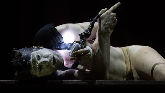 Lars Eidinger als Richard III in einer Szene mit Krone, weißem Gesicht und Mikro in der Hand liegt am Boden © Kay Nietfeld/dpa +++ dpa-Bildfunk Foto: Kay Nietfeld