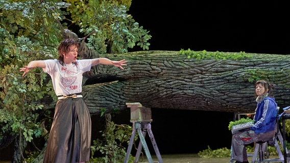 Die Schauspielerinnen Linn Reusse (l.) und Sachiko Hara vor einem liegenden Baumstumpf. © Deutsches Schauspielhaus Foto: Matthias Horn