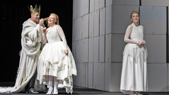 Bühnenbild von "Lear" in Hannover. Ein König streicht einer blonden Frau durchs Haar - abseits steht eine dunkelhaarige Frau und guckt betrübt. © Sandra Then Foto: Sandra Then