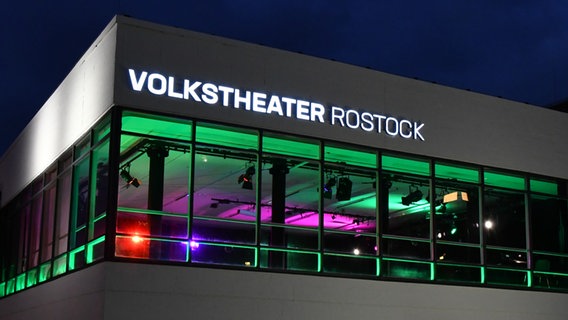 Auf einem weißen Gebäude leuchtet der Schriftzug "Volkstheater Rostock" © Dorit Gätjen 
