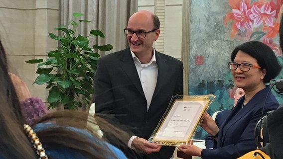 Andrew Manze präsentiert seine Urkunde als Ehren-Dirigent des Gansu Grande Theatre © NDR 