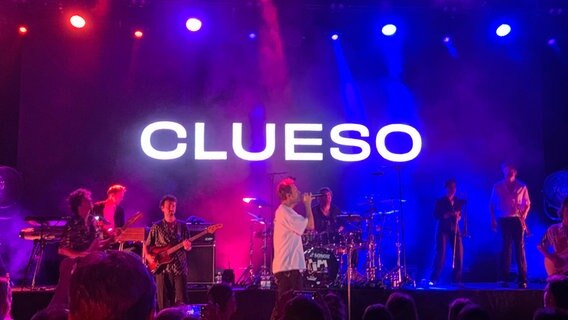 Eine Band spielt auf einer Theaterbühne, im Hintergrund wird der Künstlername "Clueso" projiziert. © NDR Foto: Sabine Hausherr
