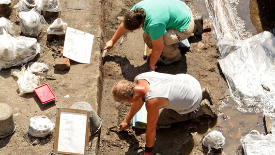 Zwei Archäologen graben in einer Grabungsstätte im Cremon in Hamburg © Archäologisches Museum Hamburg. 