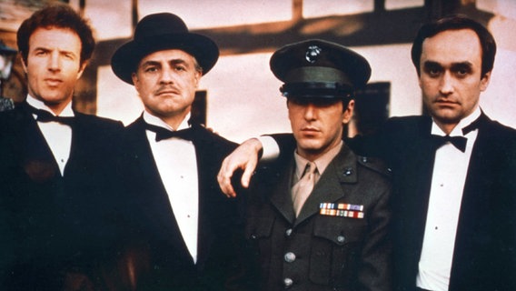 Szene aus "Der Pate" von Francis Ford Coppola (1972) mit James Caan (von links), Marlon Brando, Al Pacino und John Cazale © picture alliance/United Archives 