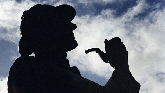 Ein Mann verkleidet als Sherlock Holmes im Gegenlicht © picture-alliance / dpa 