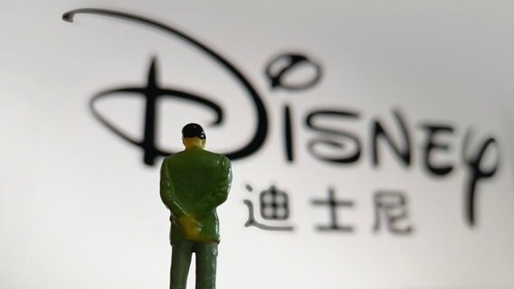 Die Figur eines Männchens steht mit hängendem Kopf vor dem Disney-Logo © picture alliance 