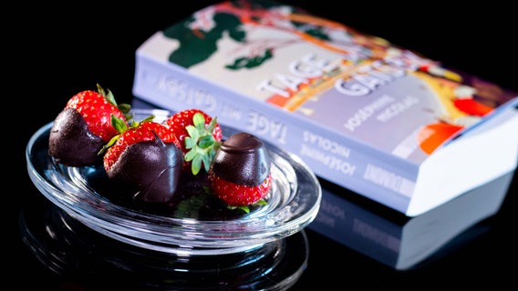 In Schokolade gestippte Erdbeeren und ein Roman auf einem Tisch - Folge 34 von eat.READ.sleep dem Literaturpodcast © NDR Foto: Claudius Hinzmann
