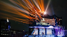Eine Lichtshow wird am 11.01.2017 in Hamburg auf und an der Fassade der Elbphilharmonie zu deren feierlicher Eröffnung gezeigt © dpa-Bildfunk Foto: Markus Scholz