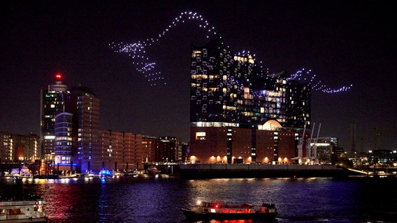 Drones illuminated by the Drift artist duo fly in formation "Breaking the waves" on the Elbe opposite the Elbphilharmonie as part of the opening of the Hamburg Music Festival.  © Georg Wendt / dpa +++ dpa photo radio +++ Photo: Georg Wendt