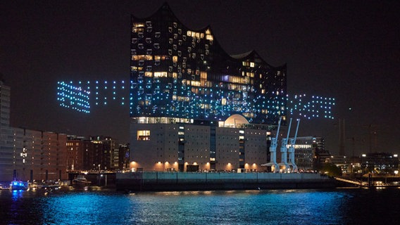 Beleuchtete Drohnen fliegen über der Elbe vor der Elbphilharmonie im Rahmen der Eröffnung des Musikfests Hamburg. © picture alliance/dpa Foto: Georg Wendt