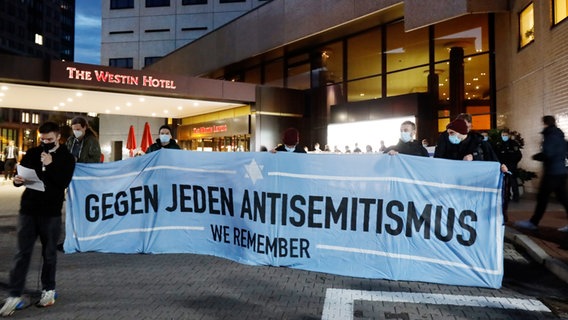 Teilnehmerinnen und Teilnehmer einer Demonstration des Bündnis "Leipzig nimmt Platz" stehen vor dem "Westin Hotel" Leipzig.  Foto: Dirk Knofe