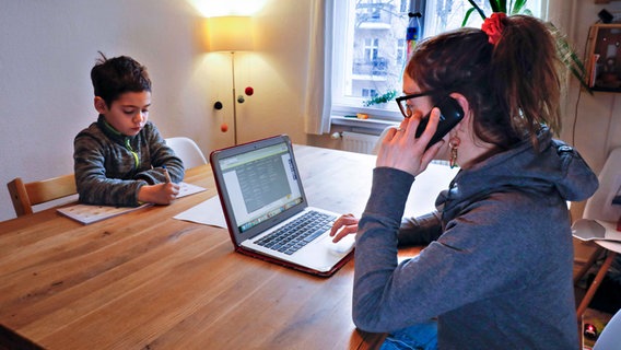 Eine berufstätige Mutter mit Kind im Homeoffice © imago Foto: Jochen Eckel