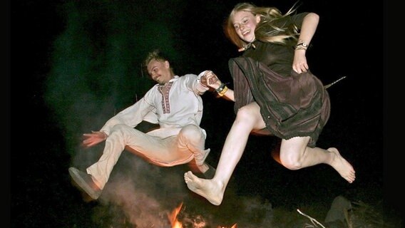 Paar springt gemeinsam über ein Feuer © epa Maxim Malinovsky Foto: Maxim Malinovsky