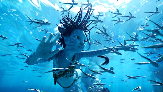 Ein Na'vi-Mädchen taucht mit Fischen  - Filmszene aus "Avatar 2 - The Way of Water" von James Cameron © Courtesy of 20th Century Studios 
