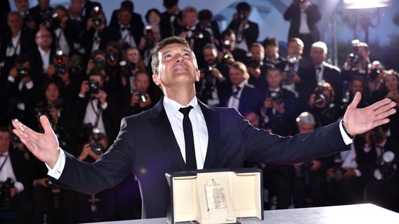 Der spanische Schauspieler blickt mit erhobenen Armen gen Himmel, vor sich die Palme als Bester Schauspieler von Cannes ©  Lionel Hahn/ABACAPRESS.COM | 