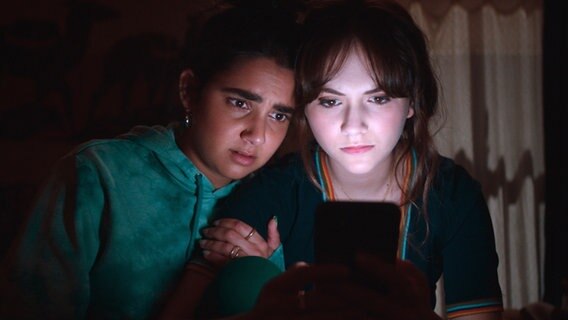 Zwei junge Frauen starren voller Angst auf einen Smartphone-Bildschirm - Geraldine Viswanathan und Emilia Jones in "Cat Person" © Studio Canal GmbH 